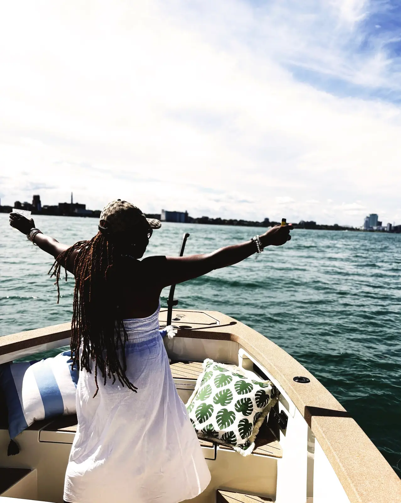 Guest standing at the bow of the Sycorax with arms outstretched near Belle Isle