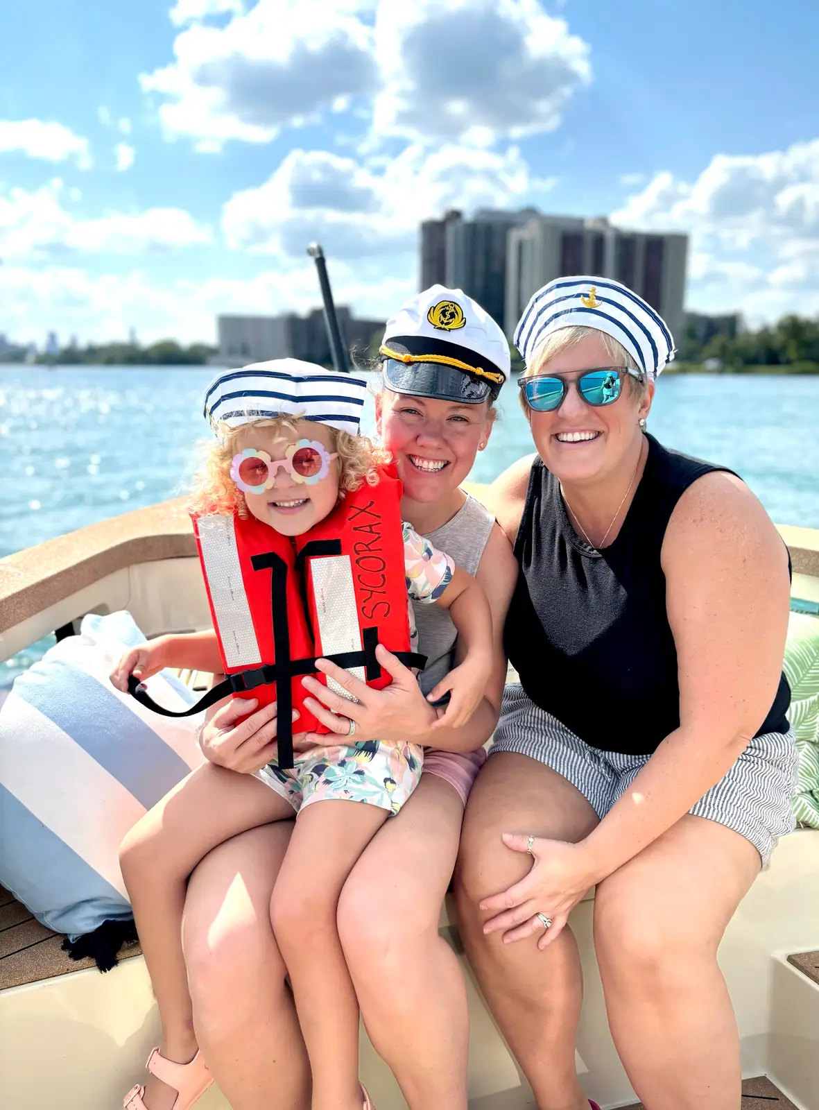 Two women and a child in sailor caps enjoying a family cruise