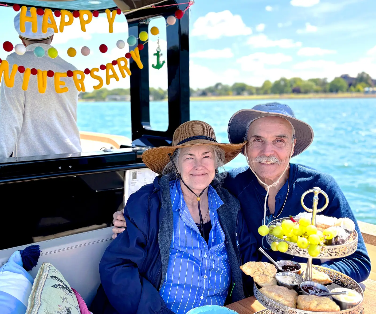 Elderly couple celebrating their anniversary with a Happy Anniversary banner aboard the Sycorax