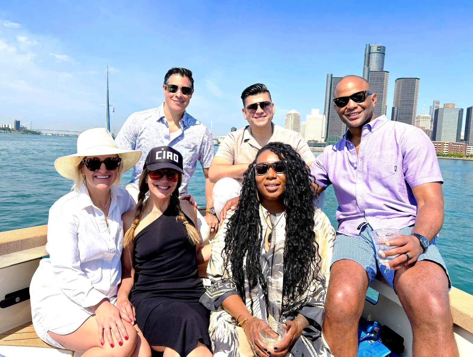 Group of six friends on the Sycorax with the Detroit skyline behind them